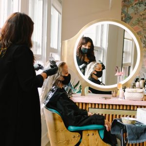 Expert hair dye services being performed on a woman in a stylish salon setting