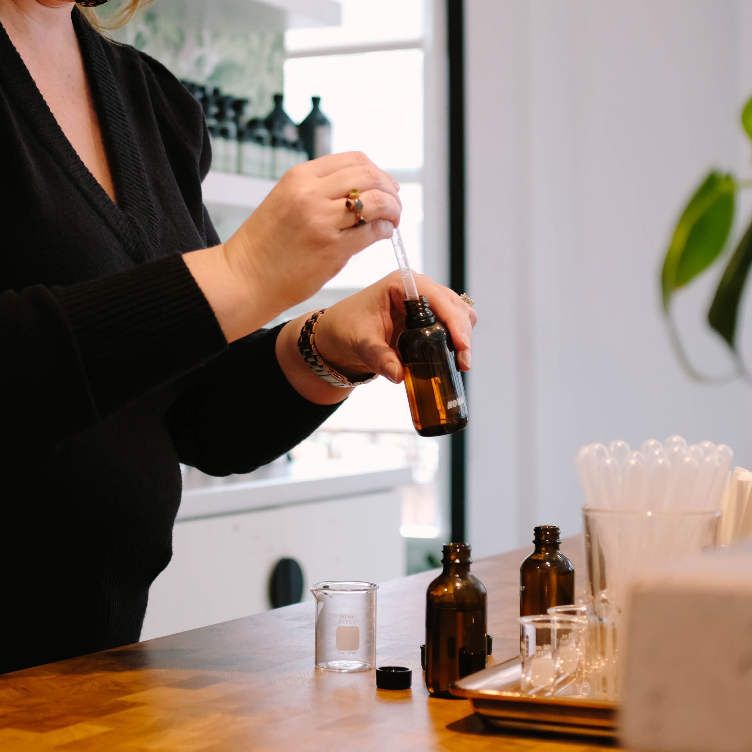 woman's hands blending a custom perfume with a vial